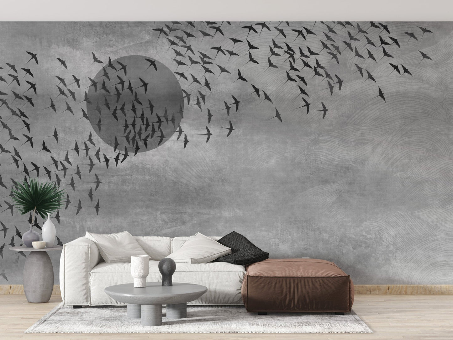 Neutral tone wall mural with bird motifs in a living room with a brown ottoman.