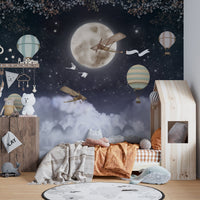 Flying Plane Over Dark Night Kids mural behind a wooden floor bed and toys.