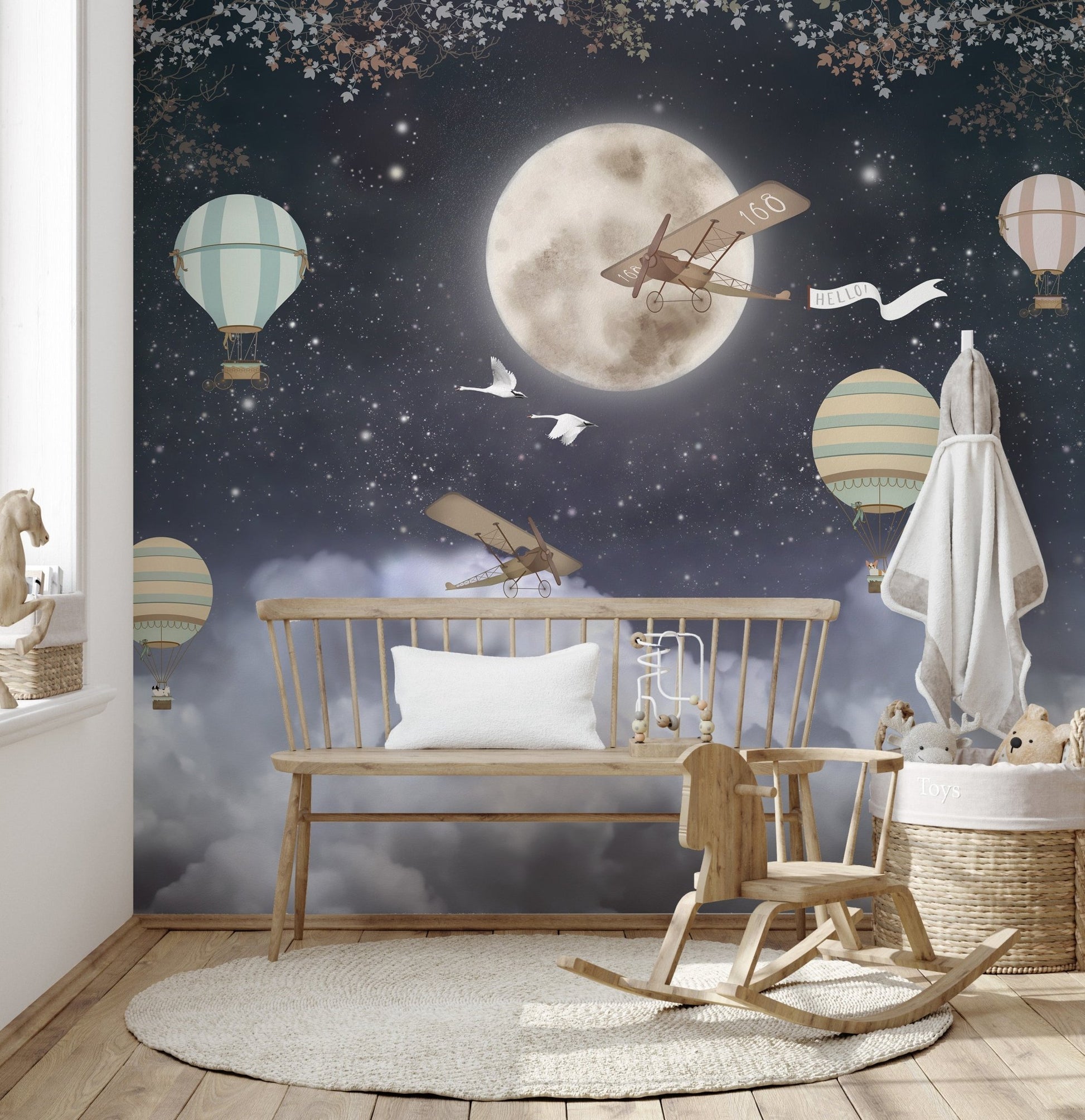 Nursery wall mural with rocking horse and bench in front of dark night design.