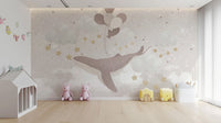 Artistic flying whale wallpaper wall mural with gold stars.