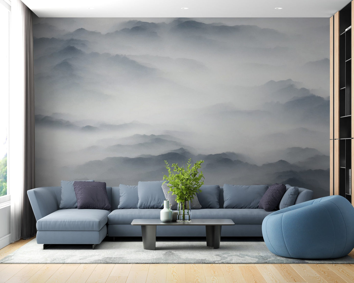Misty hill wall mural in living area with blue sectional sofa and dark coffee table.