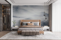 Foggy Alpine wall mural in spacious bedroom with beige bedding and wooden accents.