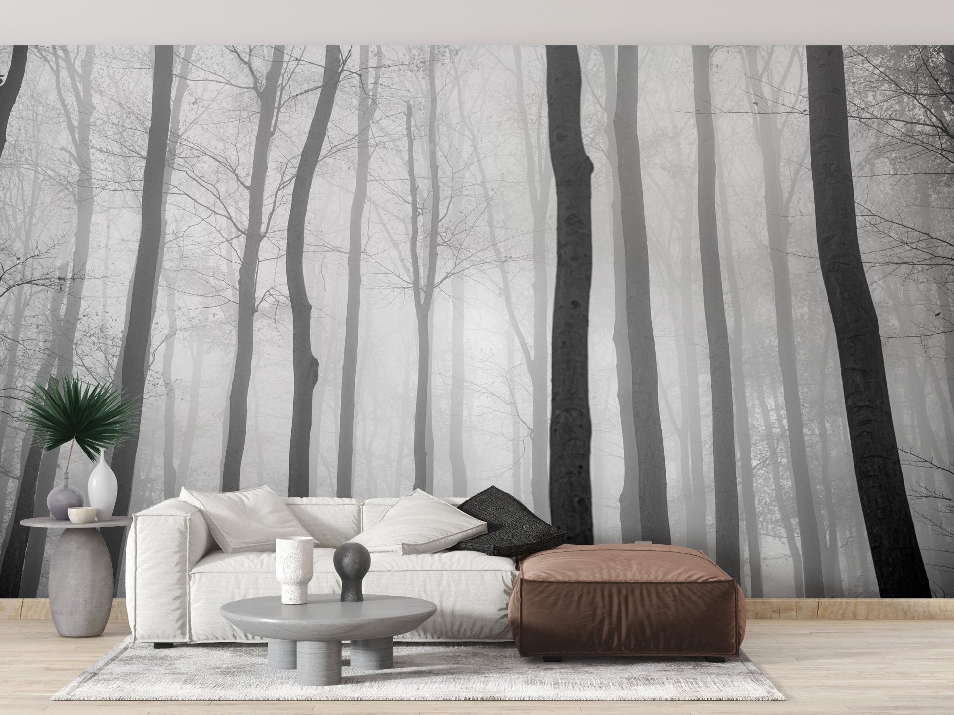Grey jungle wall mural behind a white sofa and brown ottoman in living area.
