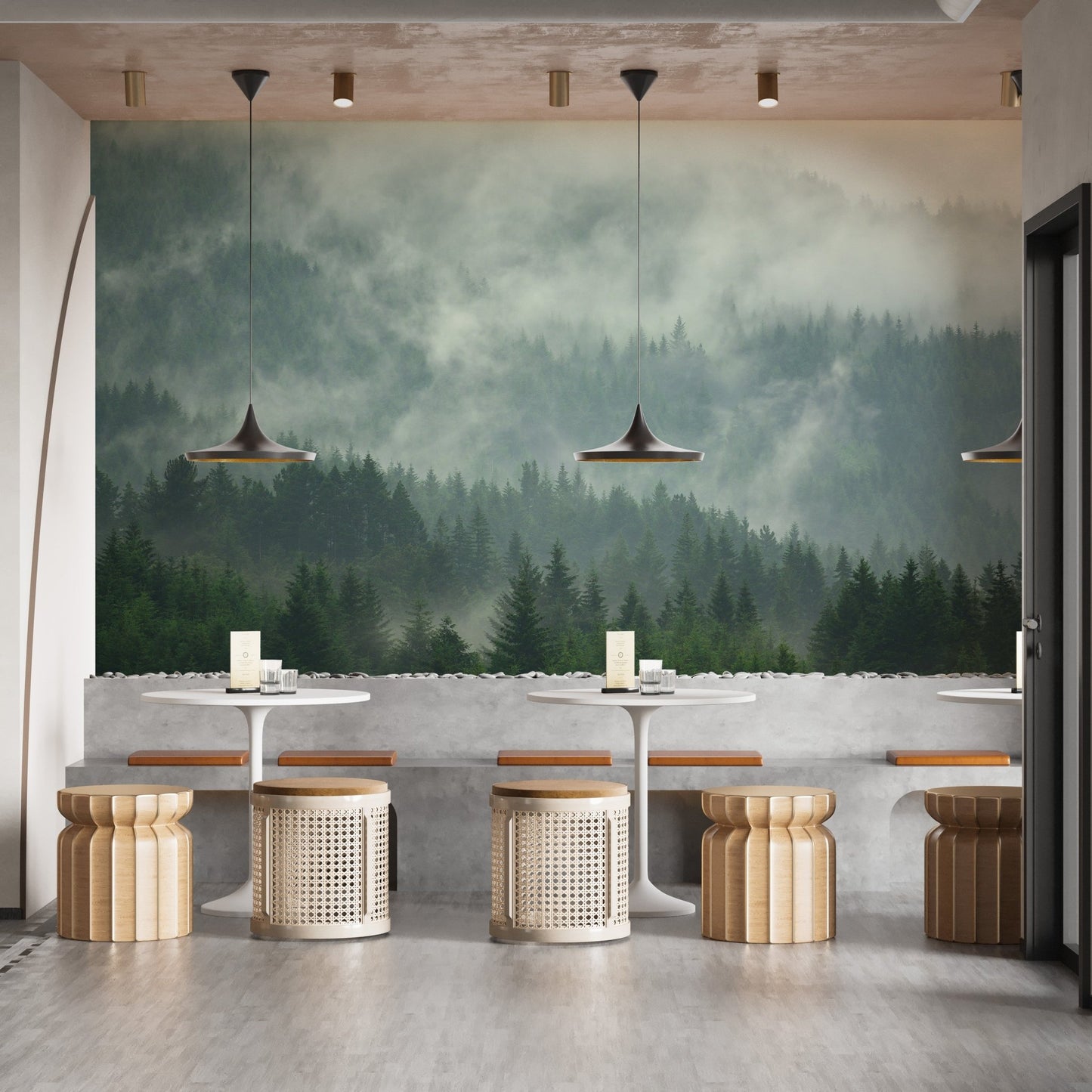 Misty forest mural in a cafe with round wooden stools and pendant lights.