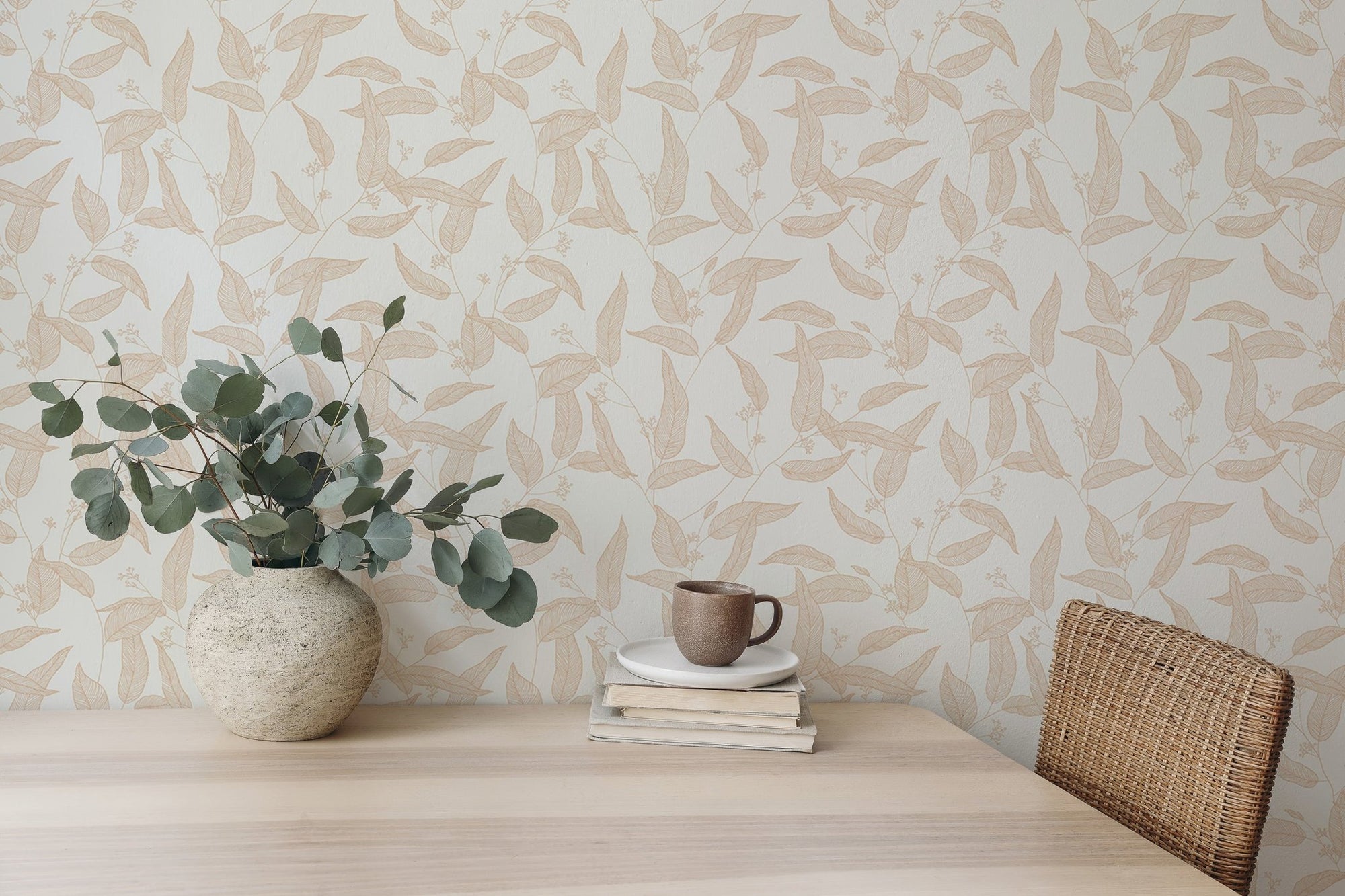 Foliage Seamless Pattern Eucalyptus Leaves wallpaper behind a desk with a vase.