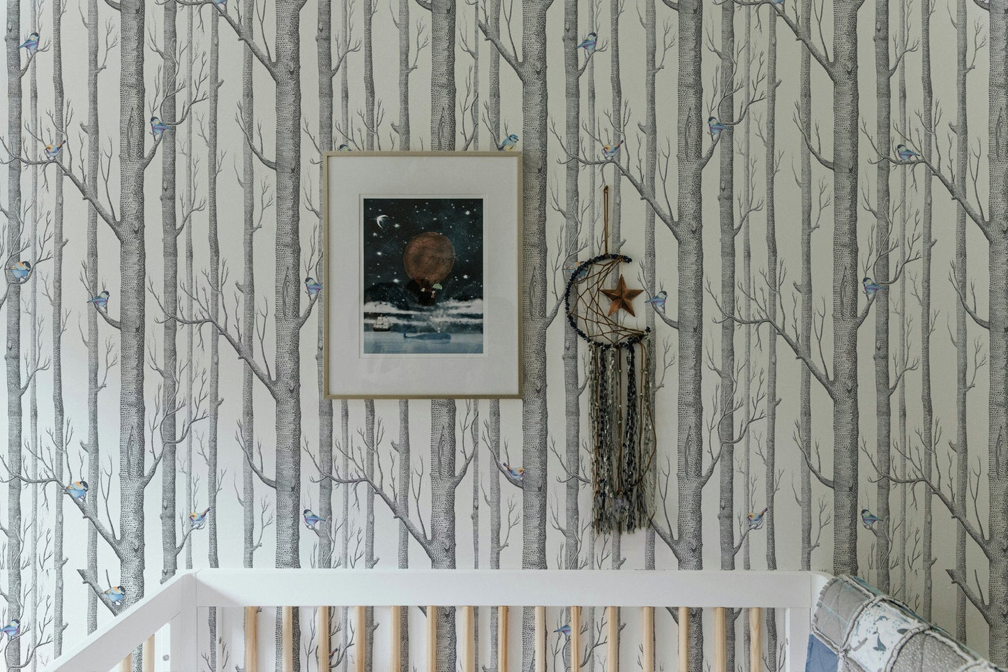 Minimalist forest wallpaper featuring thin grey branches in a light-filled room.
