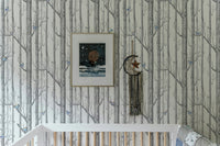 Minimalist forest wallpaper featuring thin grey branches in a light-filled room.