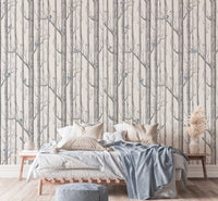 Grey and white forest wallpaper in a bright bedroom with a white bed.