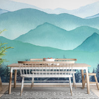 Watercolor mountain wall mural in a kitchen area with a wooden dining bench.