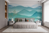 Blue and green frozen mountain wall mural behind a grey bed in a bedroom.