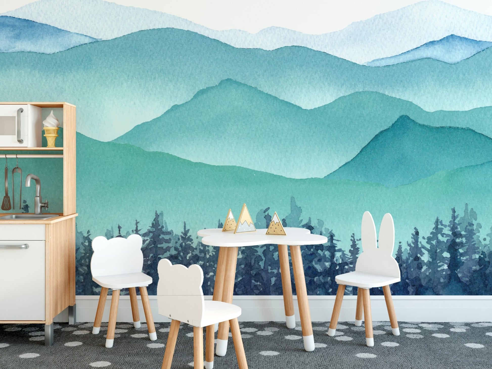 Kids' dining room featuring watercolor mountain wall mural and small white chairs.