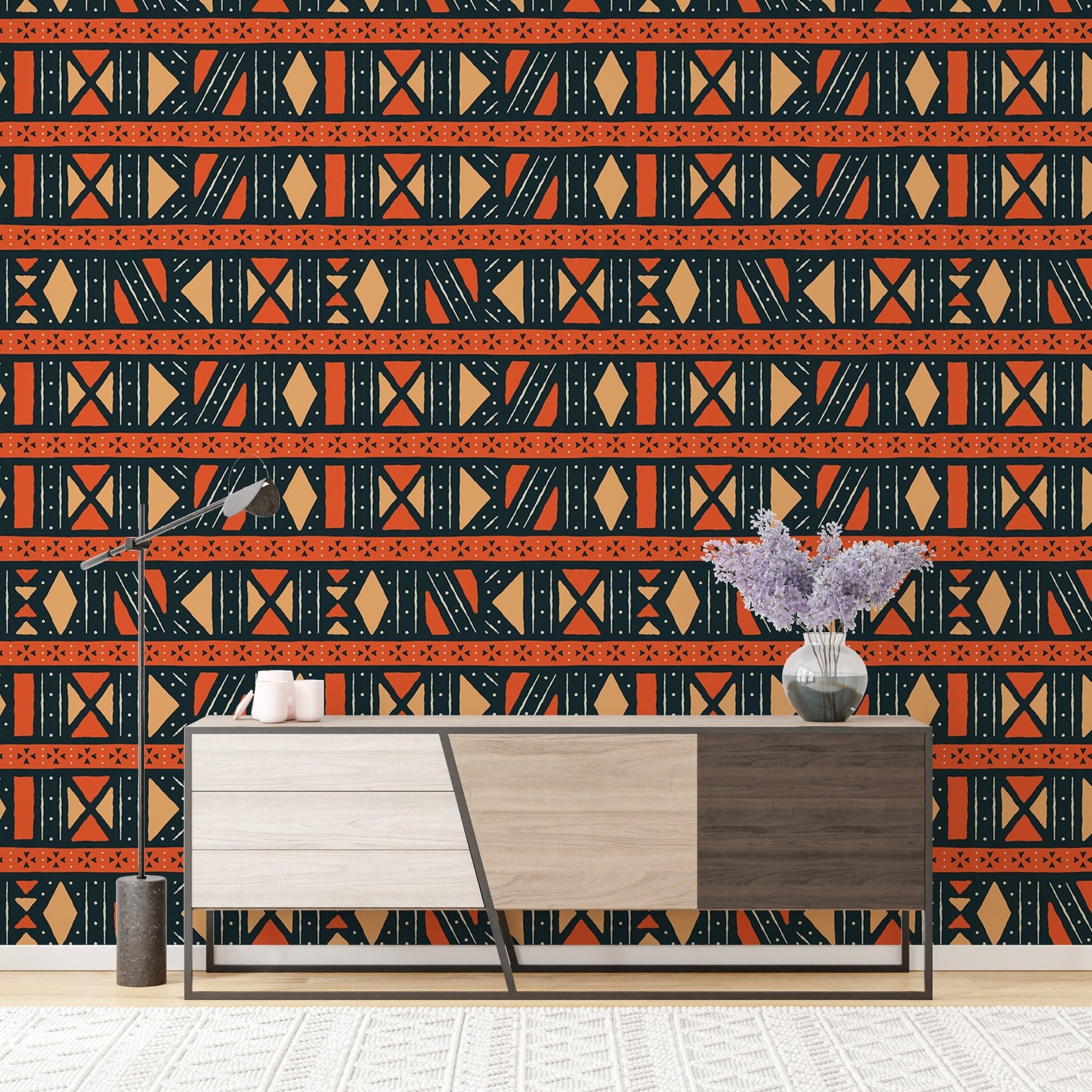 Tribal art wallpaper behind a tri-color wooden sideboard with a purple plant.