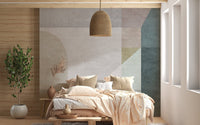 Soft pastel shapes abstract wall mural behind a wooden bed with beige bedding.