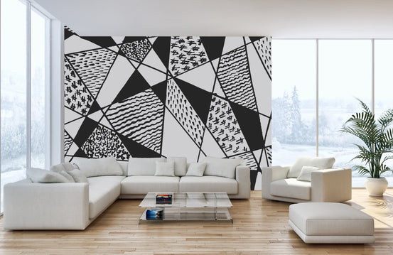 Large scale geometric wall mural in an open plan living space with white furniture.