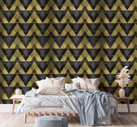 Bedroom featuring gold and black chevron wallpaper behind a white bed.