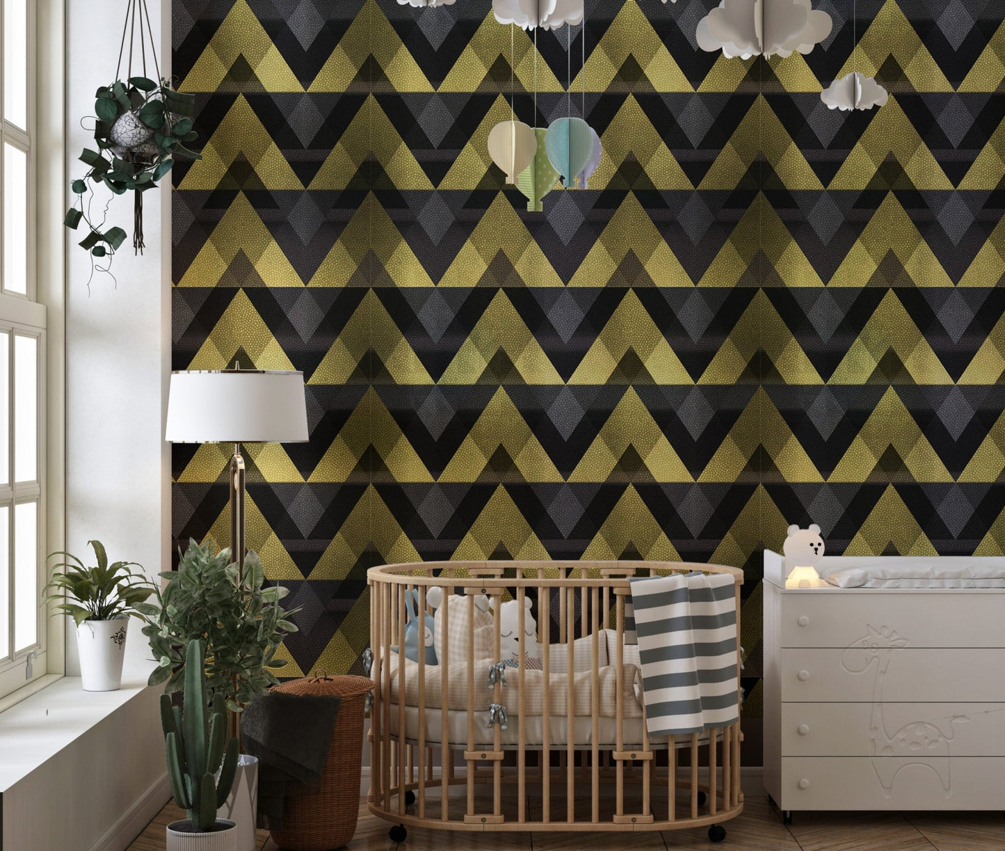 Nursery room with gold and grey chevron wallpaper behind a wooden crib.