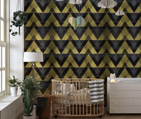 Nursery room with gold and grey chevron wallpaper behind a wooden crib.