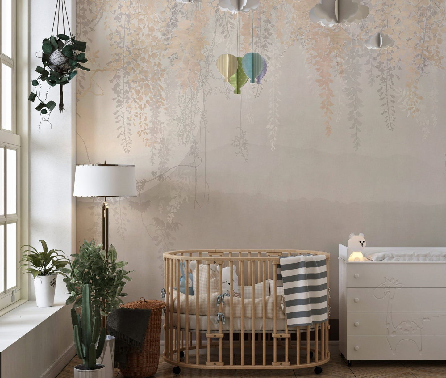 Nursery wall mural with hanging leaf designs and a wooden crib.