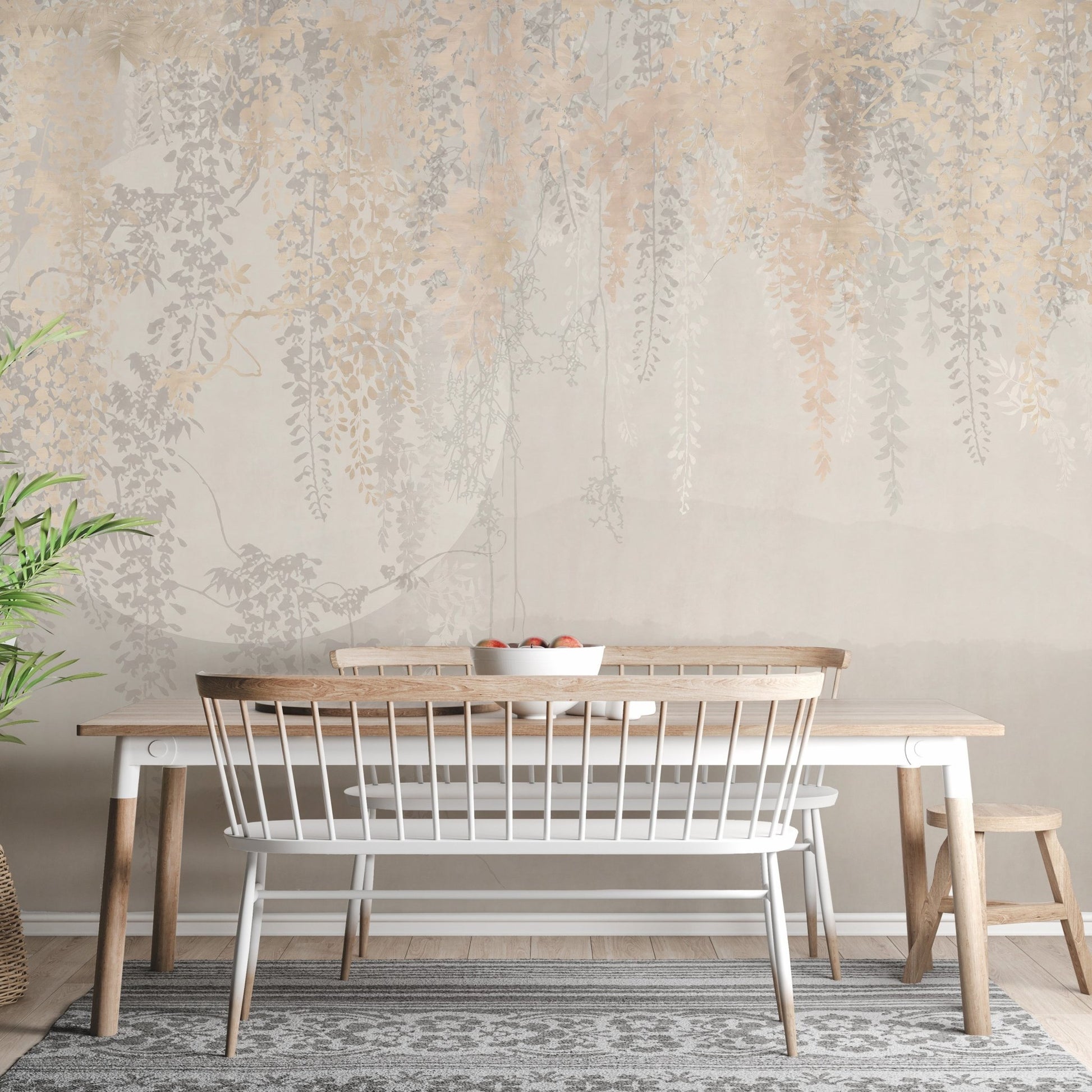 Dining space wall mural with hanging leaf patterns and a white bench.