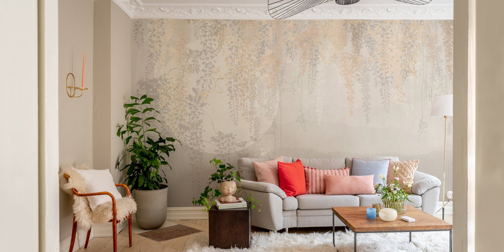 Living room wall mural with golden foliage patterns and neutral furniture.