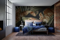 Dark bedroom with blue accents and large scale botanical leaves wall mural.