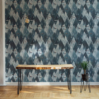 Blue mountain wallpaper behind a dark wood desk.