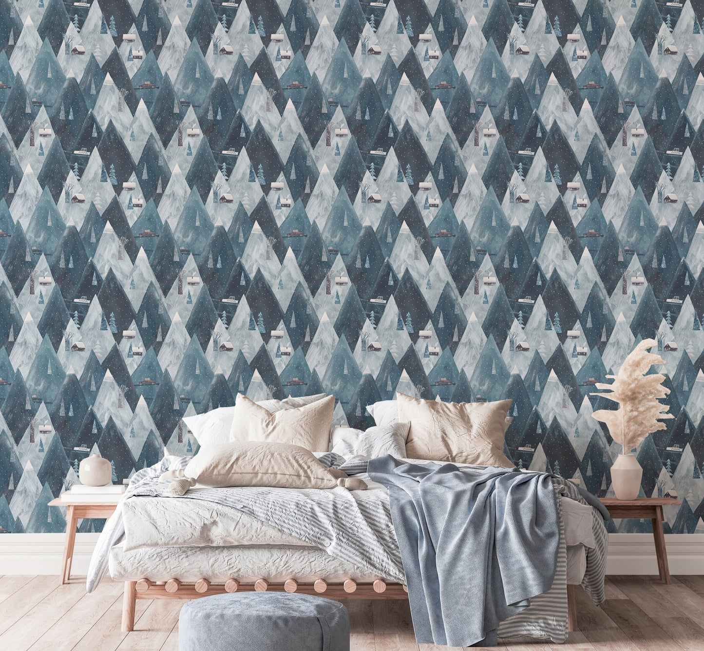 Gouache mountains houses scandinavian wallpaper behind bed with light blue linens.