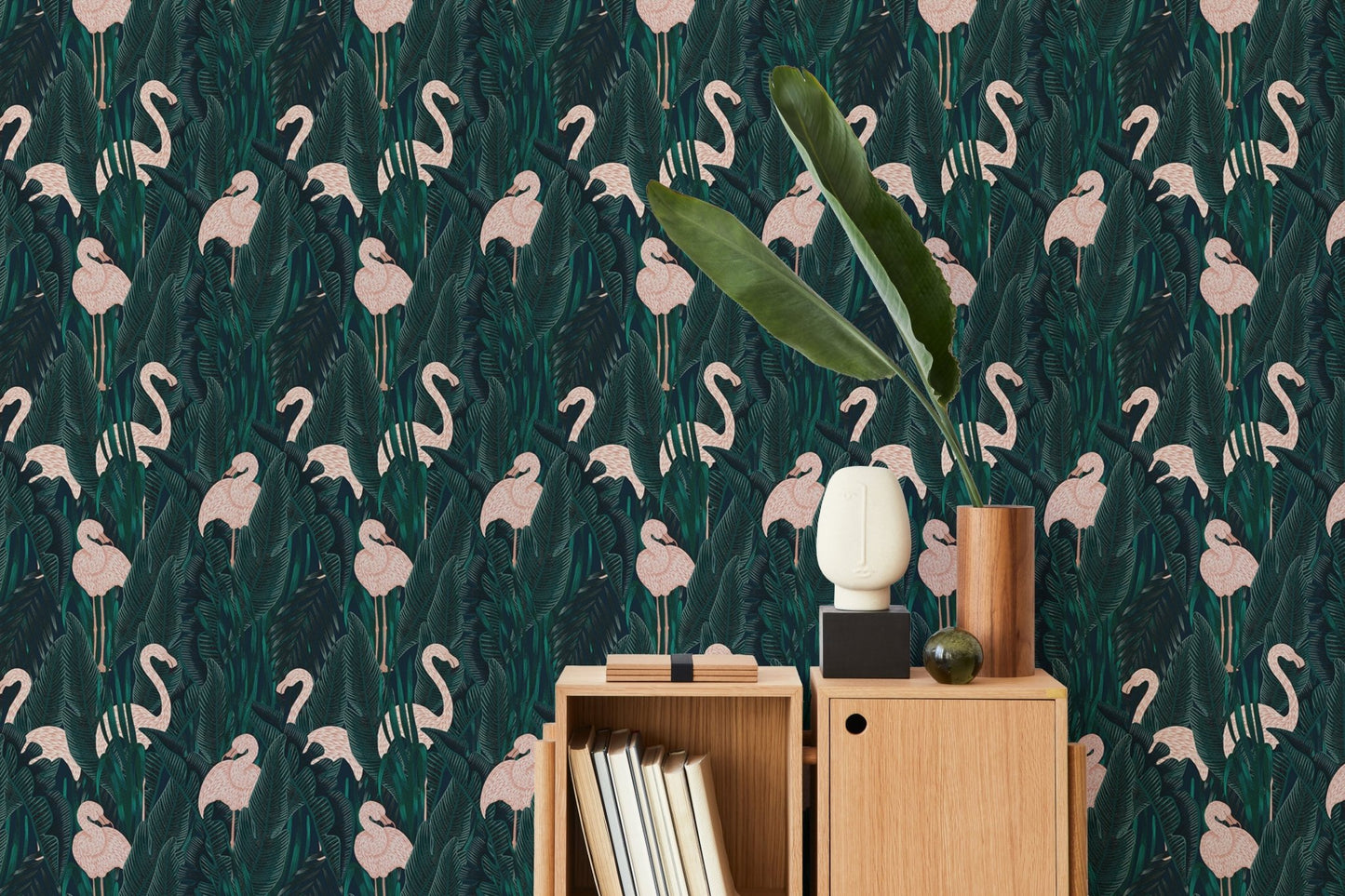 Cabinet with books placed in front of a tropical leaf and bird wallpaper.
