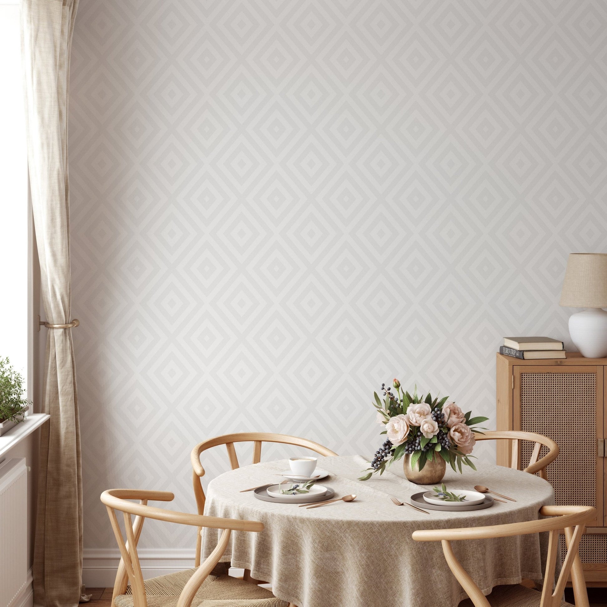 Round wooden dining table set against a large scale diamond pattern wallpaper.