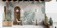 Tropical palm leaves wall mural in a minimalist cafe setting with arch decor.