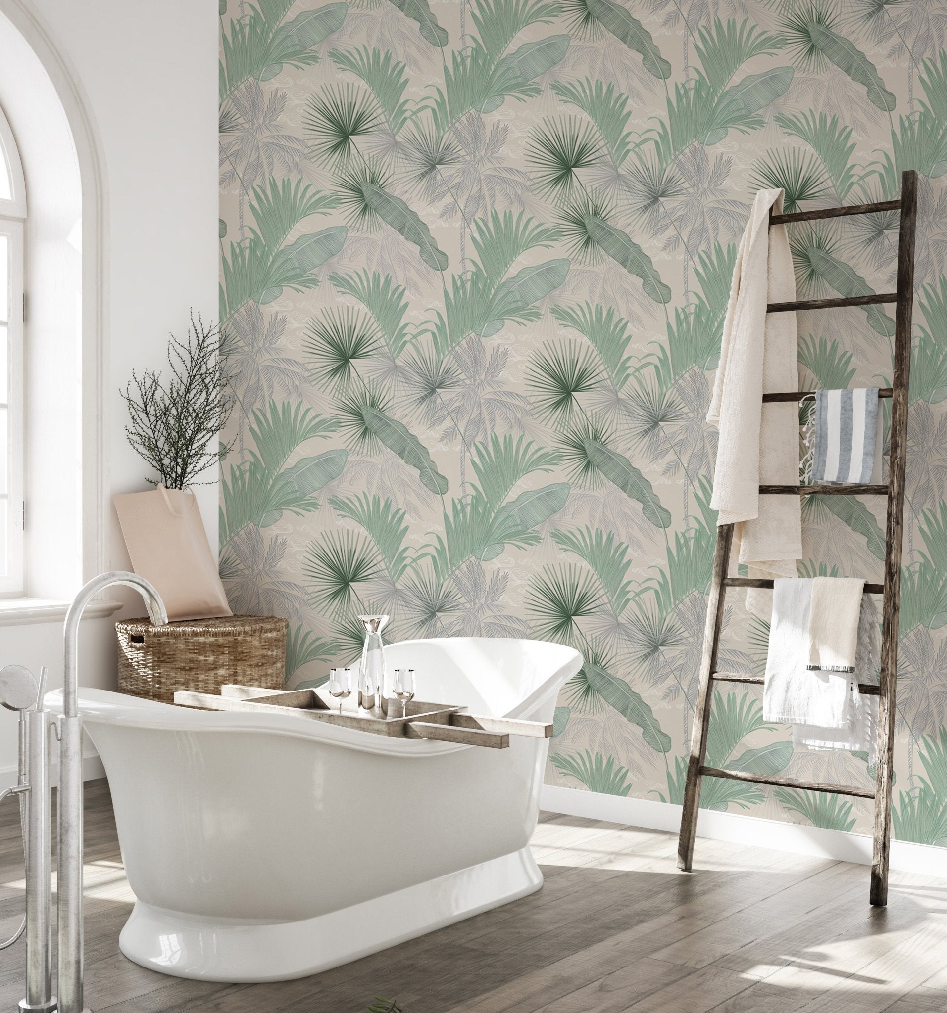 Tropical leaves wallpaper in a bathroom featuring a white freestanding bathtub.