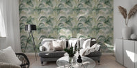 Tropical leaf wallpaper in a spacious living area with a grey sofa and white cabinets.
