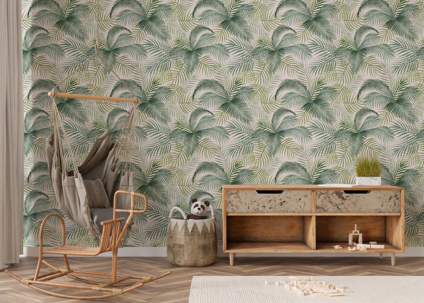 Green palm leaves repeat pattern wallpaper in a nursery with a wooden rocking chair.