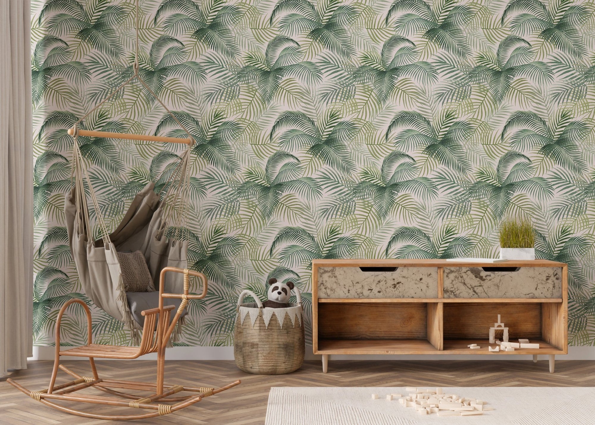 Green palm leaves repeat pattern wallpaper in a nursery with a wooden rocking chair.