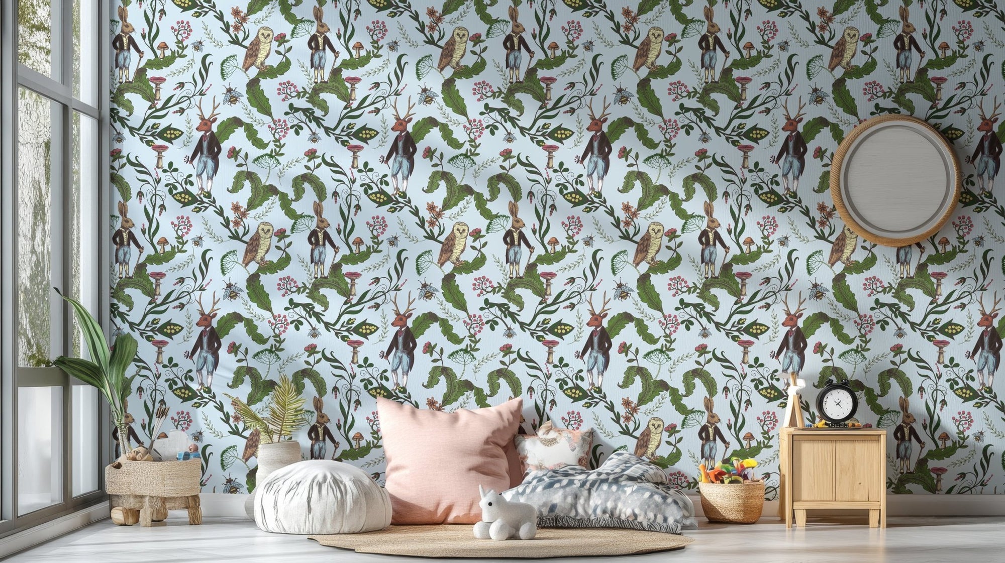 Green leaves with rabbit and owl wallpaper in a kids bedroom with pink pillows.