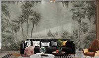 Tropical trees and leaves wall mural in soft green tones for living room.