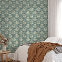 Damask pattern wallpaper behind a bed with brown and white bedding.