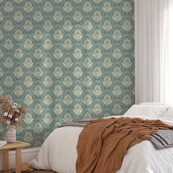Damask pattern wallpaper behind a bed with brown and white bedding.