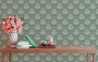 Floral baroque wallpaper behind a wooden table with a pink flower vase.