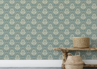 Textured damask wallpaper on a living area wall with a wooden bench and basket.