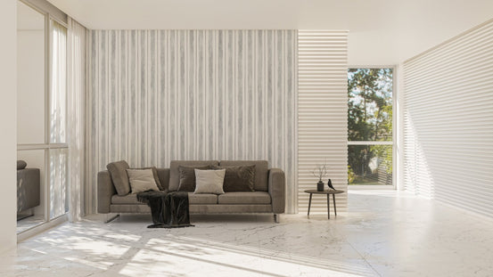 Large living space with a grey sofa and seamless striped wallpaper