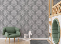 Grey damask pattern wallpaper in a kids playroom with a green chair.
