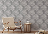 Grey damask wallpaper in a reading area with a woven chair.