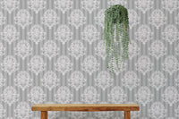 Vintage damask wallpaper behind a wooden bench and hanging plant.