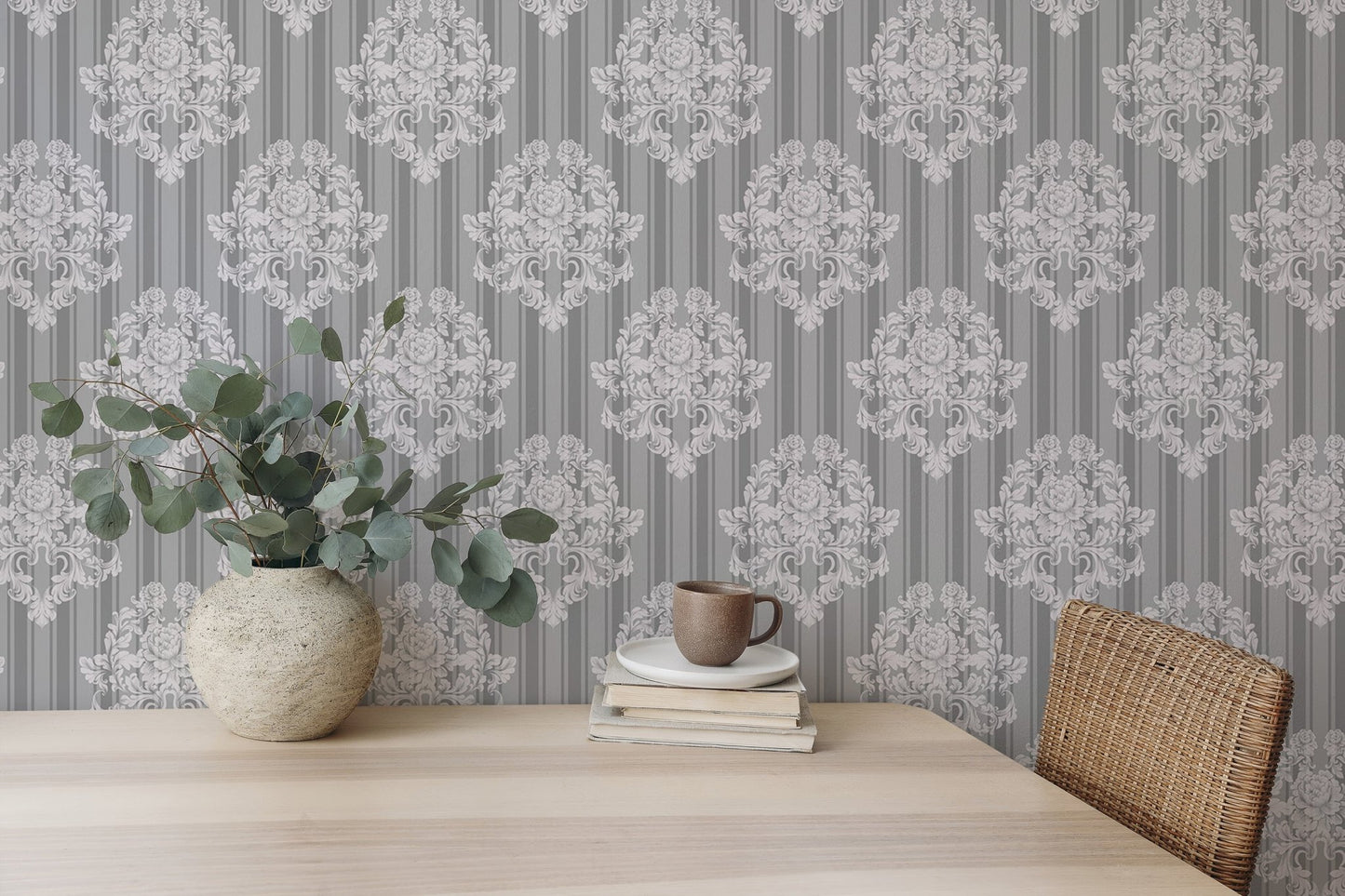 Damask wallpaper on a study room wall with a wooden table.