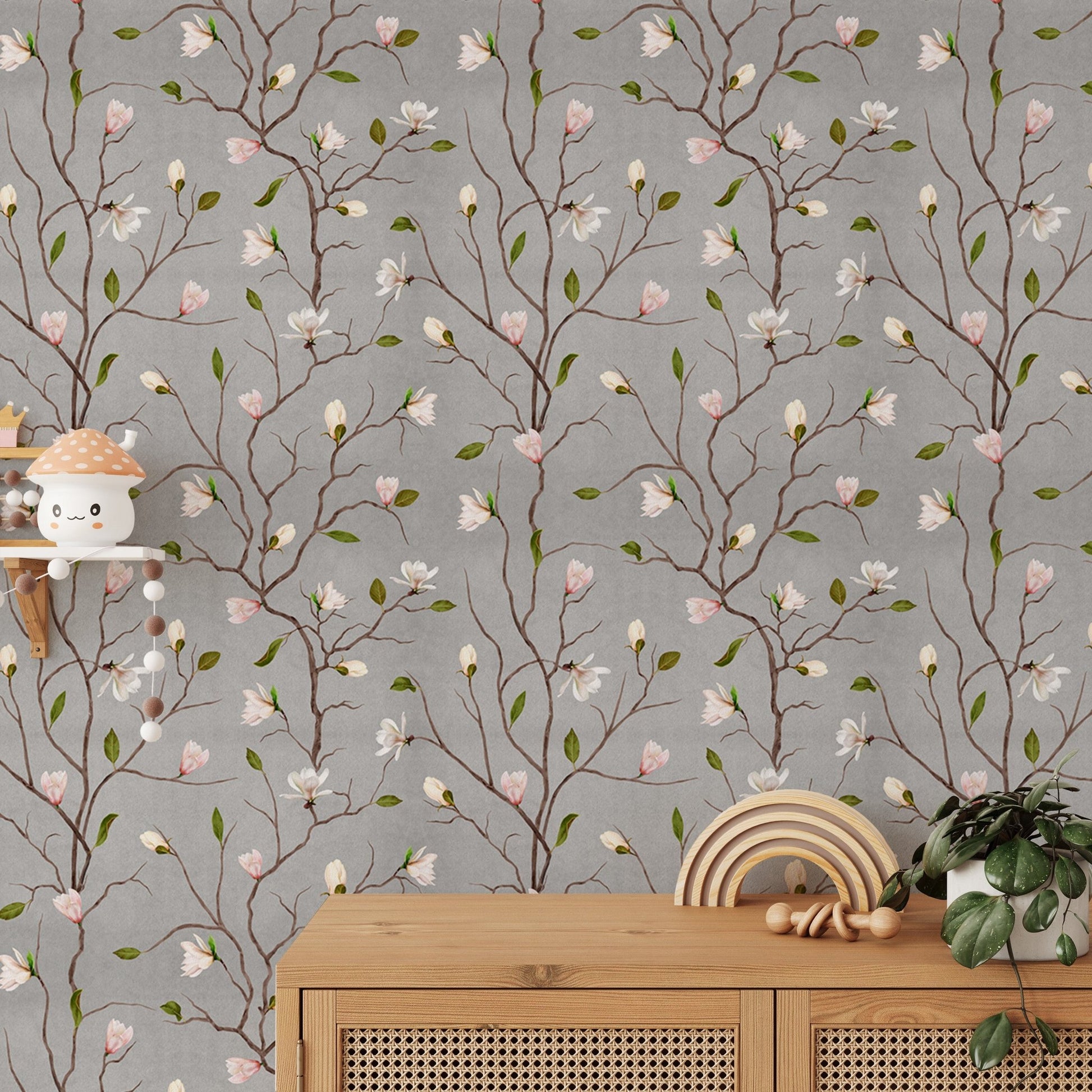 Flower wallpaper with pink blossoms on a grey background behind a wooden cabinet.