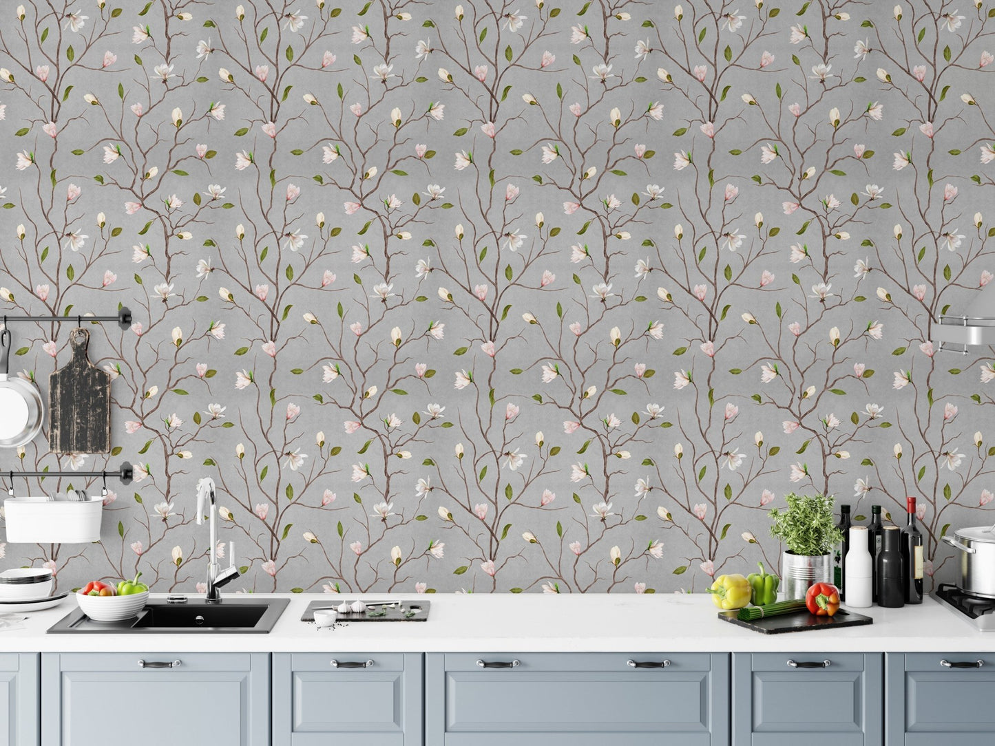Magnolia blossom wallpaper behind a white kitchen counter with fresh vegetables.