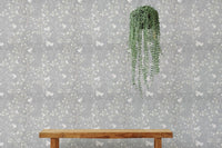 Hanging plant against a grey Chinoiserie wallpaper in a bright interior.