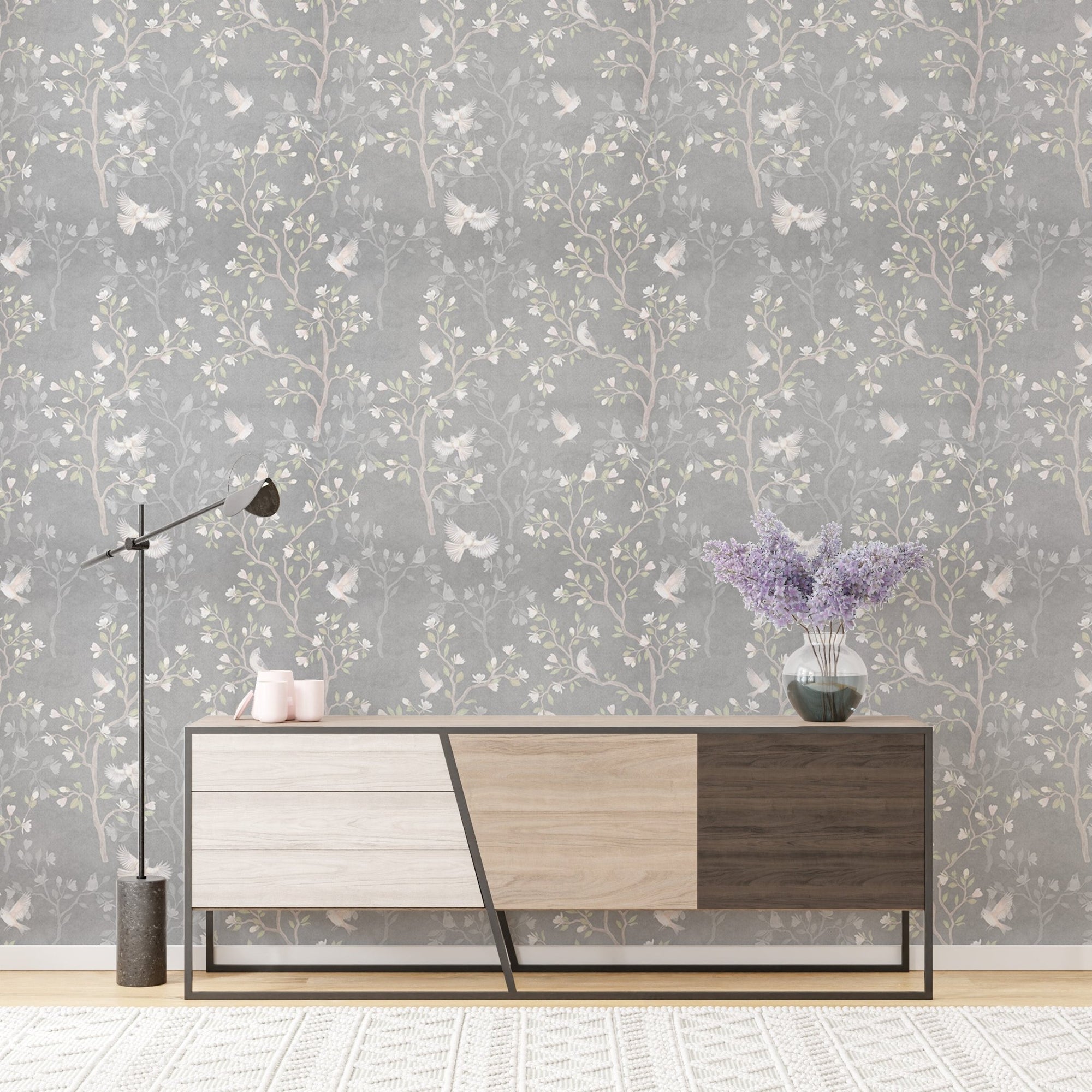 Grey Chinoiserie wallpaper with magnolia trees behind a modern wooden sideboard.