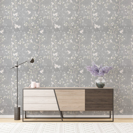 Grey Chinoiserie wallpaper with magnolia trees behind a modern wooden sideboard.